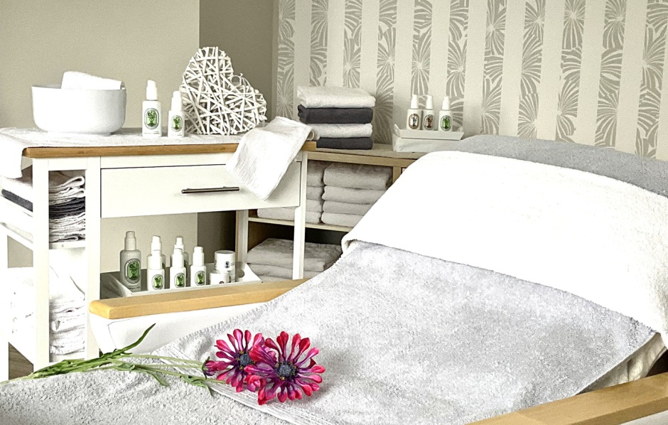 Behandlungsraum mit Pflegeprodukten, Handtüchern und Naturkosmetik
